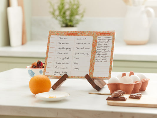 Recipe card on a stand with ingredients on a table